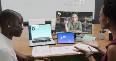 Ofisteki çeşitli iş kadınları ekranlarda video mesajı ve mesajlaşmalı bilgisayarlar kullanıyor. İş, ofis, iletişim ve dijital arayüz teknolojisi.