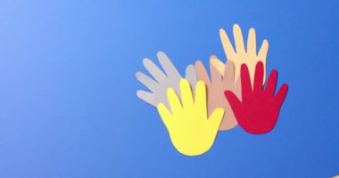 Mavi arkaplanda fotokopi alanı olan renkli kağıtlardan yapılmış elleri birleştirin. Topluluk, küresel, insanlar ve sanat.