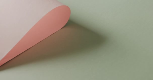 淡い緑色の背景にピンクのロール紙を閉じ ゆっくりとした動きでコピースペースを持ちます テクスチャ — ストック動画