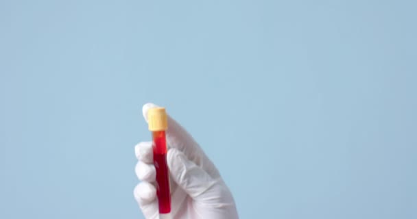 Ręka Nosząca Rękawicę Medyczną Trzymająca Próbkę Krwi Niebieskim Tle Przestrzenią — Wideo stockowe