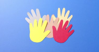 Mavi arkaplanda fotokopi alanı olan renkli kağıtlardan yapılmış elleri birleştirin. Topluluk, küresel, insanlar ve sanat.