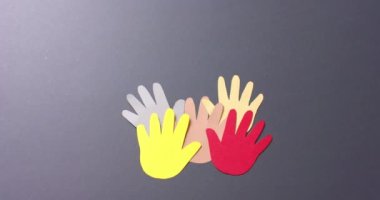 Gri arkaplan ve fotokopi alanı olan renkli kağıtlardan yapılmış elleri birleştirin. Topluluk, küresel, insanlar ve sanat.