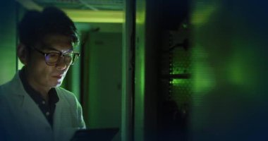 Sunucu odasındaki Asyalı erkek çalışanın dünya ve veri işleme animasyonu. Küresel teknoloji ve dijital arayüz konsepti dijital olarak oluşturulmuş video.