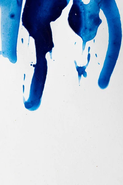 Close up of blue paint shapes on white background with copy space. Abstract background, pattern and colour.