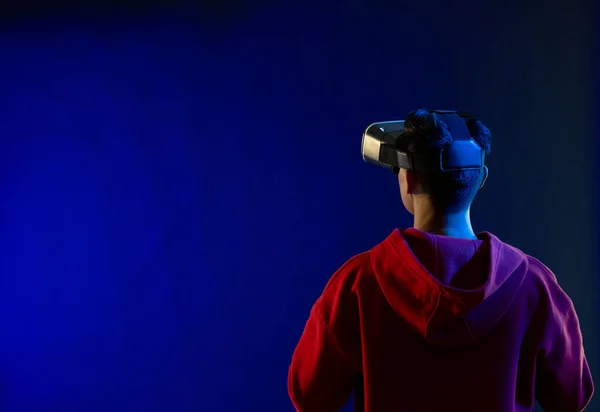 コピースペースのある青い光のスタジオでVrヘッドセットを使用するアジア人男性 仮想現実とデジタルインターフェース技術 — ストック写真
