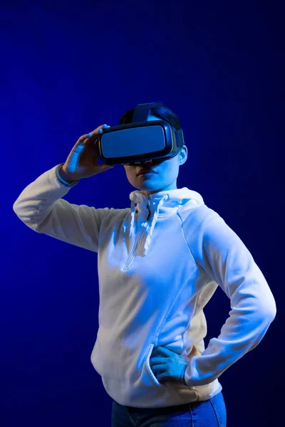 コピースペースのある青い光のスタジオでVrヘッドセットを持つアジアの女性 仮想現実とデジタルインターフェース技術 — ストック写真