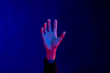 Stüdyoda eli açık Asyalı bir adam. Fotokopi odası olan mavi ışık. Sanal gerçeklik ve dijital arayüz teknolojisi.