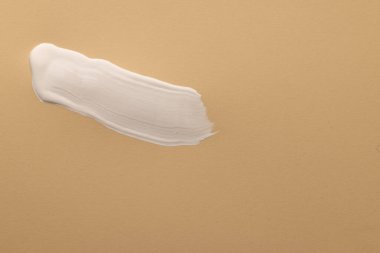 Bej arka plandaki beyaz boya şeridini fotokopi alanı ile kapatın. Soyut arkaplan, desen ve renk.