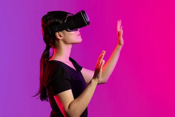 ピンクと紫の光とコピースペースのスタジオでVrヘッドセットを使用してアジアの女性 仮想現実とデジタルインターフェース技術 — ストック写真