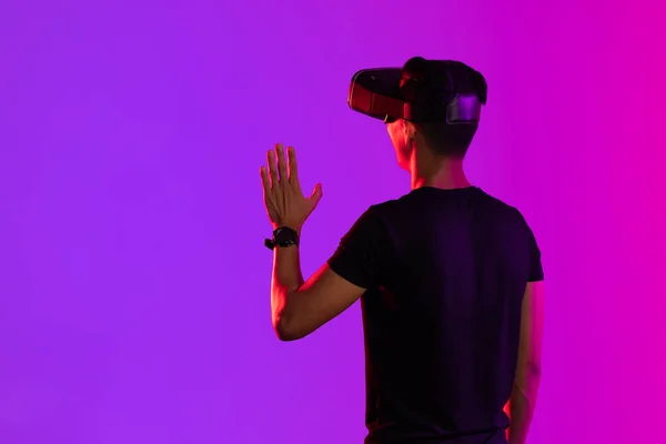 紫色の光とコピースペースのスタジオでVrヘッドセットを使用してアジアの男 仮想現実とデジタルインターフェース技術 — ストック写真