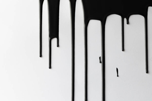 Close up of black paint shapes on white background with copy space. Abstract background, pattern and colour.