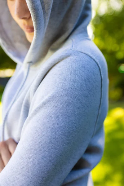 stock image Close up of caucasian woman wearing gray hoodie over green park on sunny day. Clothing, material and model.