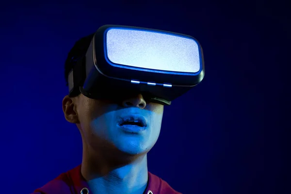 コピースペースのある青い光のスタジオでVrヘッドセットを使用するアジア人男性 仮想現実とデジタルインターフェース技術 — ストック写真