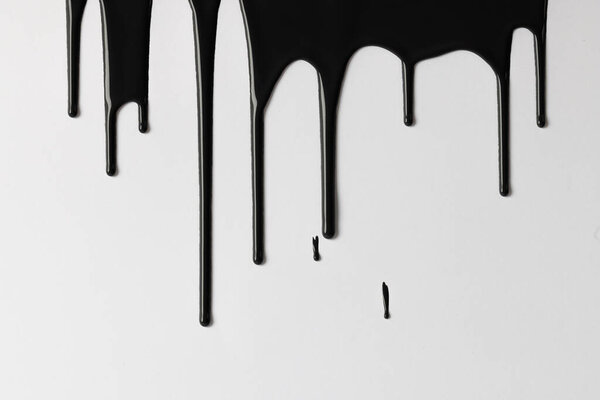 Close up of black paint shapes on white background with copy space. Abstract background, pattern and colour.