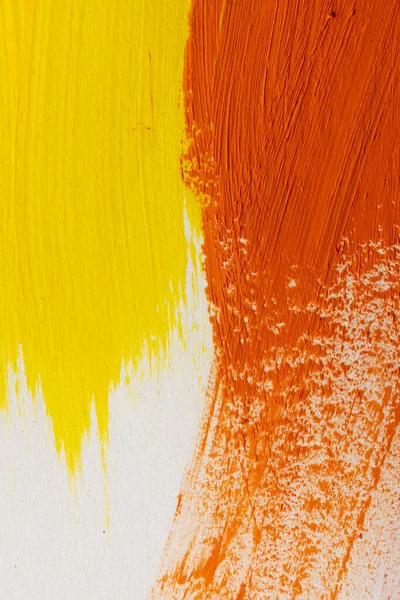 Close up of yellow and orange paint stripes on white background with copy space. Abstract background, pattern and colour.
