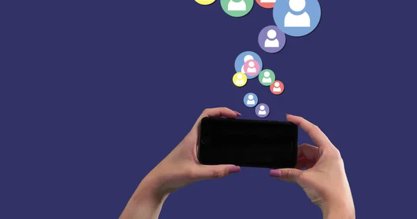 在社交图标上使用智能手机的人在蓝色背景上漂浮的图像 全球经济和技术概念数字组合 — 图库照片