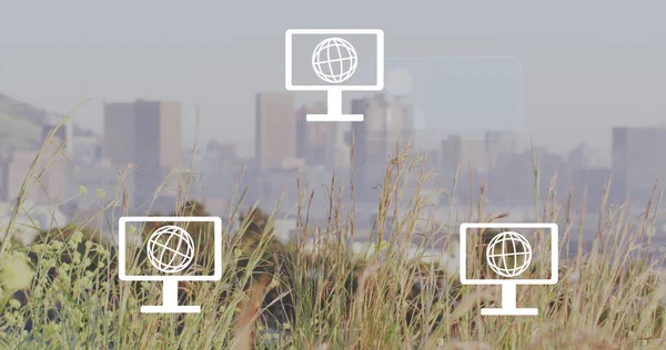 Image of network of screen icons with globes and envelopes over cityscape. Global networks, business, finances, computing and data processing concept digitally generated image.