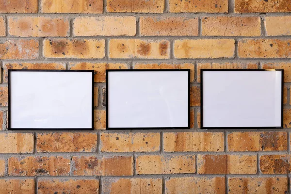 レンガの壁に対してコピースペースを持つ白い空のフレーム フレームテンプレート インテリアデザインと装飾をモックアップ — ストック写真