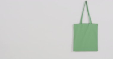 Beyaz arkaplandaki yeşil çantayı kapat, boşluğu kopyala, yavaş çekim. Moda, tasarım ve kumaş.