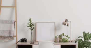 Beyaz zemin üzerinde kopya alanı olan ahşap çerçeve ve masa üzerinde beyaz duvarla birlikte bitki. Çerçeve, ev dekorasyonu ve iç tasarım konsepti.