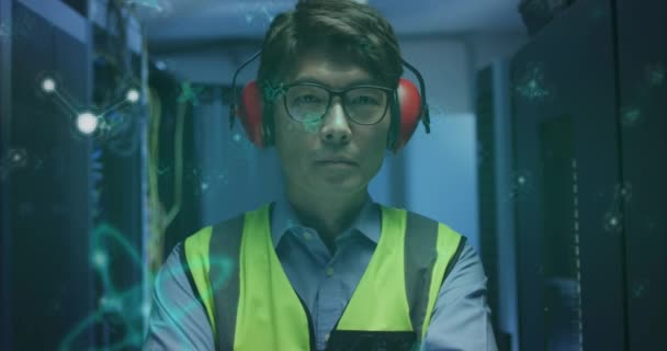 サーバールームに立つアジア系男性エンジニアの上に浮かぶ分子構造のアニメーション 医学研究科学とビジネスデータ保存技術の概念 — ストック動画