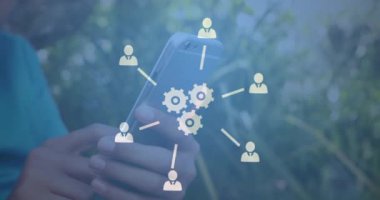 Çift ırklı çocuğun orta kesiminde akıllı telefon kullanarak dönen birden fazla dijital simgenin animasyonu. Bilgisayar arayüzü ve iş ağı teknolojisi kavramı