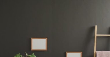 Beyaz zemin üzerinde kopya alanı olan ahşap çerçeve ve gri duvarda bitkiler. Çerçeve, ev dekorasyonu ve iç tasarım konsepti.