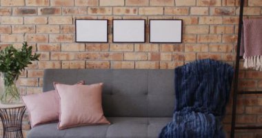 Üç ahşap çerçeve, tuğla duvarında kopya alanı olan bitki ve kanepe. Çerçeve, resim, iç tasarım ve ev dekorasyonu.