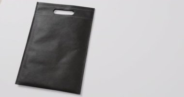 Beyaz arkaplandaki siyah çantayı kapat, boşluğu kopyala, yavaş çekim. Moda, tasarım ve kumaş.