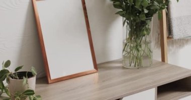 Beyaz zemin üzerinde kopya alanı olan ahşap çerçeve. Masasında beyaz duvarlar olan bitkiler. Çerçeve, ev dekorasyonu ve iç tasarım konsepti.