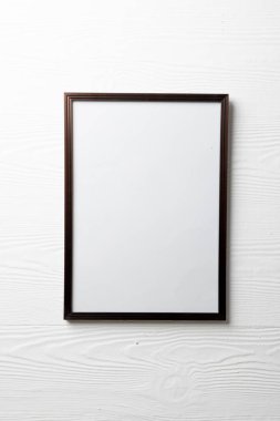 Beyaz duvarda kopyalama alanı olan boş, siyah ahşap çerçevenin dikey hali. Çerçeve şablonu, iç tasarım ve dekorasyonu düzenle.