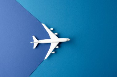 Mavi arka plandaki beyaz uçak modelini fotokopi alanı ile kapatın. Seyahat, ulaşım ve tatil.