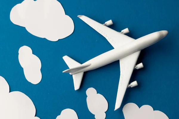 青い背景に雲と白い飛行機モデルのクローズアップ — ストック写真