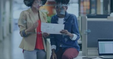 Animation of financial data processing over diverse businesswomen in office. Global business, finances, computing and data processing concept digitally generated video.