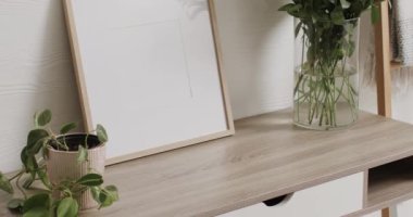 Beyaz zemin üzerinde kopya alanı olan ahşap çerçeve. Masasında beyaz duvarlar olan bitkiler. Çerçeve, ev dekorasyonu ve iç tasarım konsepti.