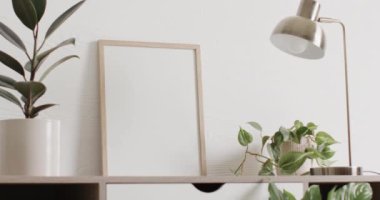 Beyaz zemin üzerinde kopya alanı olan ahşap çerçeve. Masasında beyaz duvarlar olan bitkiler. Çerçeve, ev dekorasyonu ve iç tasarım konsepti.
