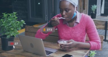Afro-Amerikan bir kadının bir kafede yemek yiyip dizüstü bilgisayar kullanması üzerine sosyal medya ikonu canlandırması. Sosyal medya ağı ve iş teknolojisi kavramı