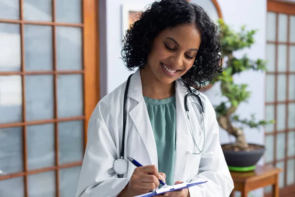 Happy Biracial Female Doctor Holding Clipboard Taking Notes Doctor Office — Stock Photo, Image