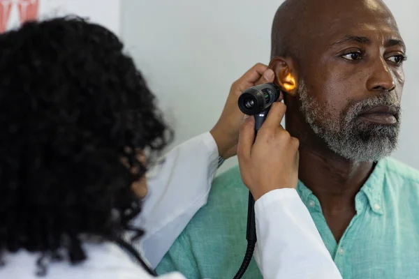 Biracial Female Doctor Using Otoscopy Examinating African American Male Patient — Stock Photo, Image
