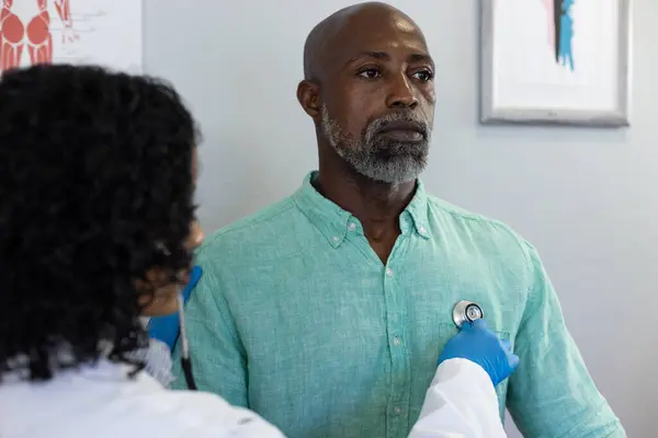 Biracial Kvinnlig Läkare Med Stetoskop Och Undersöka Afrikansk Amerikansk Manlig — Stockfoto