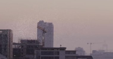 Beyaz parçacıkların canlandırılması şehir manzarasının havadan görüntüsüne karşı bir nft metin pankartı oluşturur. Kripto para birimi ve iş teknolojisi kavramı