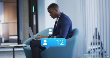 Afro-Amerikan iş adamının ofisindeki simge ve veri işleme animasyonları. Küresel iş, finans, hesaplama ve veri işleme kavramı dijital olarak oluşturulmuş video.