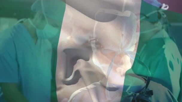 Animación Ondear Bandera Nigeria Contra Equipo Diversos Cirujanos Que Realizan — Vídeo de stock