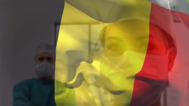 病院の白人男性と女性の外科医に対してベルギー旗を振ってのアニメーション 医療技術の概念 — ストック動画