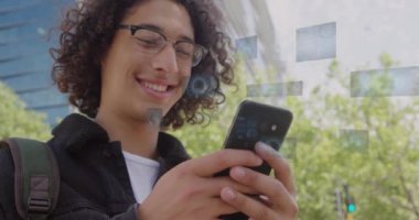 Çift ırklı adamın akıllı telefon kullanarak veri işlediği dijital ekranların animasyonu. Küresel iş ve dijital arayüz kavramı dijital olarak oluşturulmuş video.