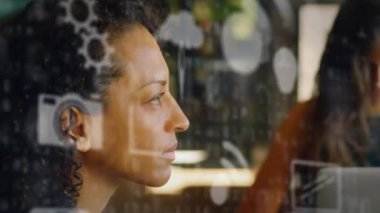 Ofisteki düşünceli çift ırklı kadına karşı ikili kodlar üzerine birden fazla ikon animasyonu. Dijital bileşik, çoklu pozlama, fikirler, yön, iş, kodlama, rapor, kodlama ve teknoloji.