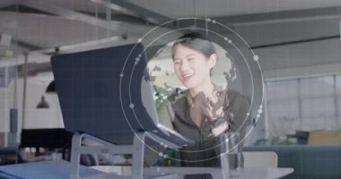 Bilgisayarı kullanan Asyalı mutlu iş kadınının veri işleme ve küresinin animasyonu. Küresel iş ve dijital arayüz kavramı, dijital olarak oluşturulmuş video.