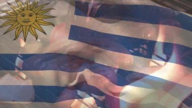 Sosis ve mangalda pişen sebzelerin üzerinde sallanan uruguay bayrağının animasyonu. Dijital bileşim, yemek, hazırlık, vatanseverlik, özgürlük, kimlik ve kutlama konsepti.