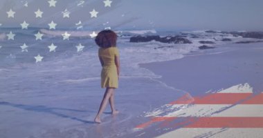 Sahilde yürüyen Afrikalı Amerikalı bir kadının dikiz aynasından Amerikan bayrağının animasyonu. Bağımsızlık Günü farkındalık kavramı