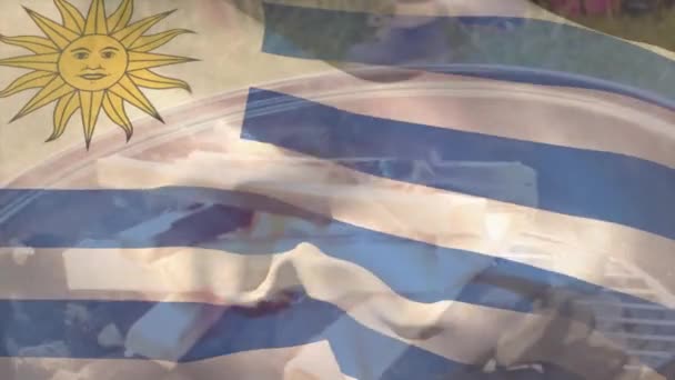 バーベキューグリルで燃える薪の上に手を振るウルグアイの旗のアニメーション デジタル複合体 愛国心 アイデンティティとお祝いの概念 — ストック動画